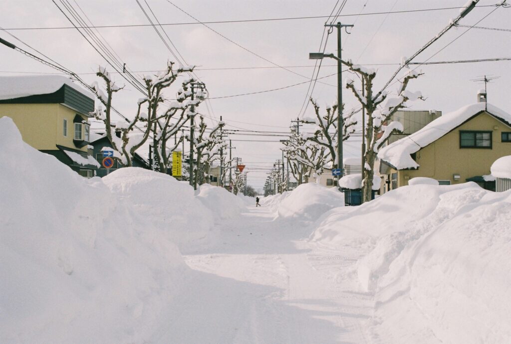 建物1階の高さまで積み上げられた雪と、除雪された道路